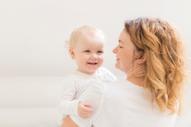 Entzückendes Baby, glücklich, mit Mutter zu sein