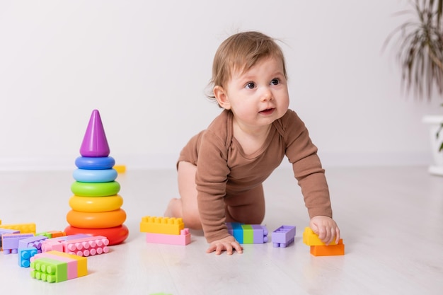 entzückendes baby im braunen hemd, das mit spielzeug spielt, kartenbanner, platz für text