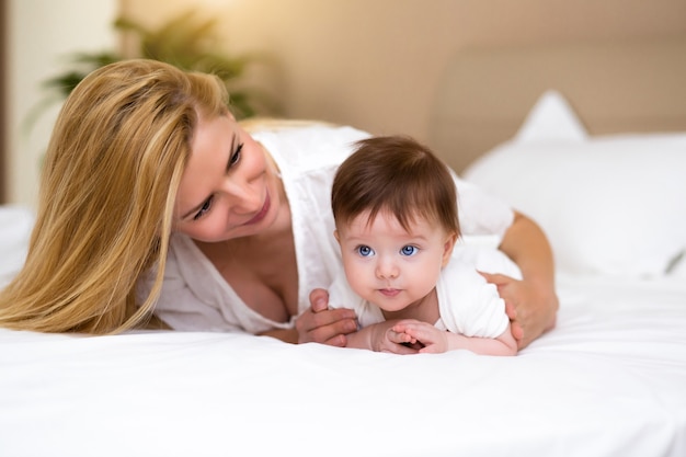 Entzückendes Baby im weißen, sonnigen Schlafzimmer hat eine Bauchzeit Neugeborenes Kind entspannt