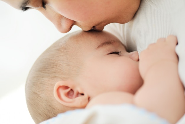 Entzückendes Baby in den Armen der Mutter