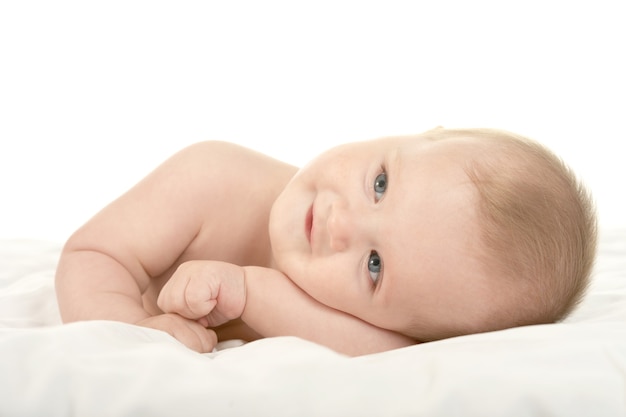 Entzückendes Baby liegt auf einer Decke auf weißem Hintergrund