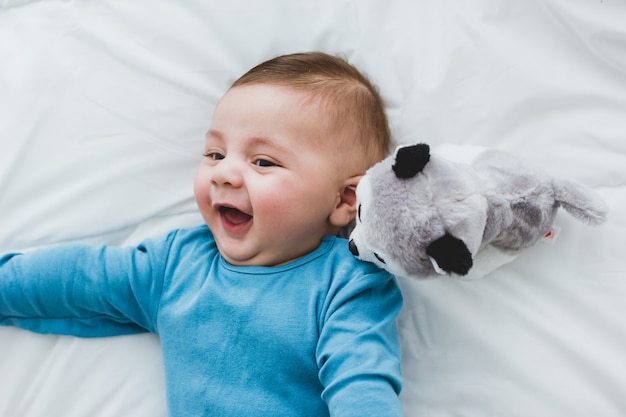 Entzückendes Baby mit einem Spielzeughund an seiner Seite