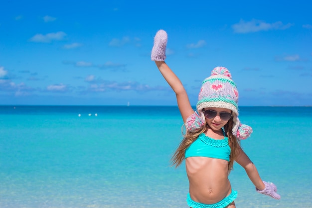 Entzückendes glückliches kleines Mädchen, das Spaß auf tropischem Strand hat