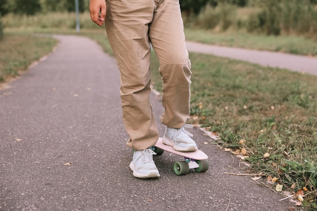 Entzückendes glückliches Mädchen, das Skateboard im Park reitet