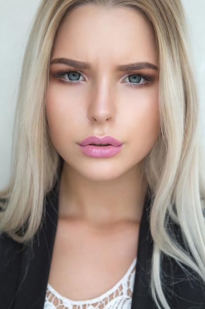 Entzückendes junges blondes Model mit natürlichem Make-up und langen glatten Haaren