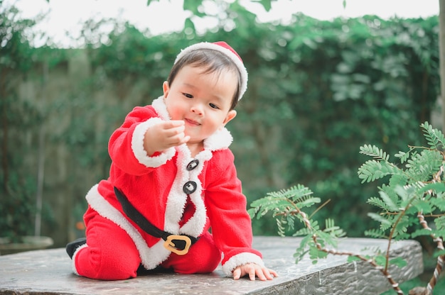 Entzückendes kleines Baby im Weihnachtsmann-Outfit