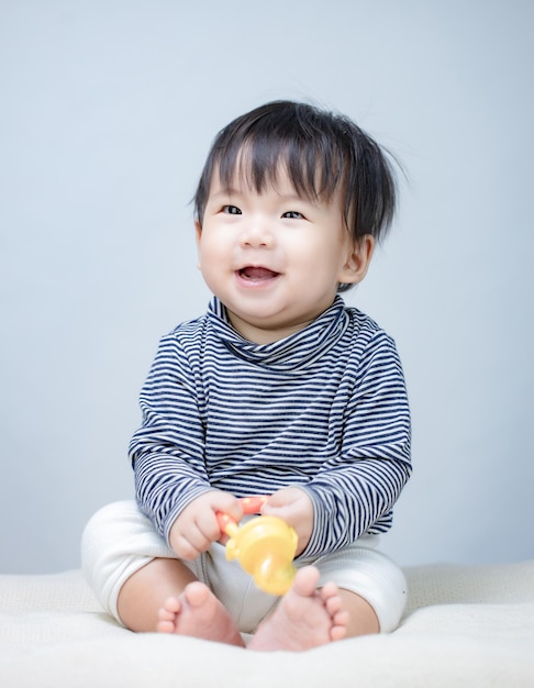 Entzückendes kleines Baby mit Futterspender Silikonfrucht Orange