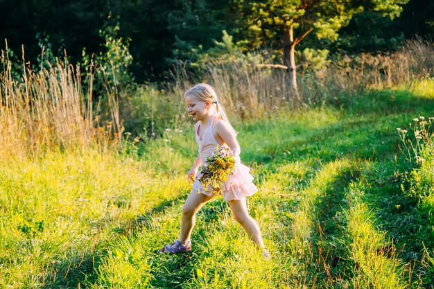 Entzückendes kleines blondes Mädchen mit Wildblumen