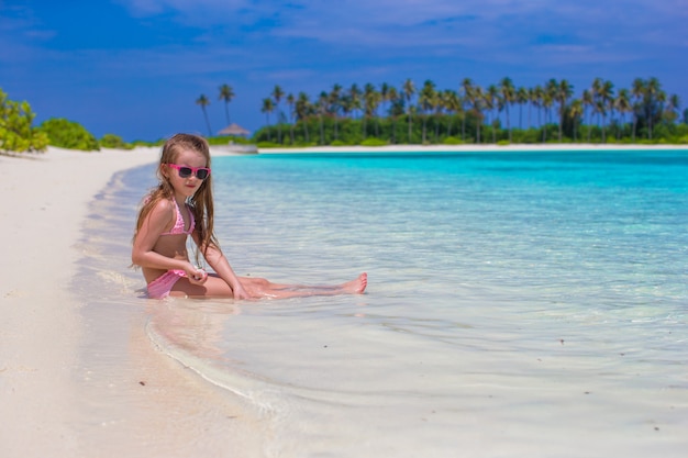 Entzückendes kleines Mädchen am Strand während der Sommerferien