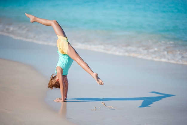 Entzückendes kleines Mädchen am weißen Strand während der Sommerferien