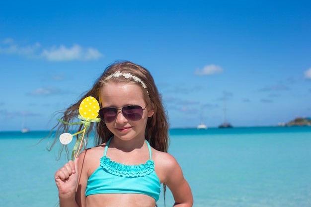 Entzückendes kleines Mädchen am weißen Strand während der Sommerferien