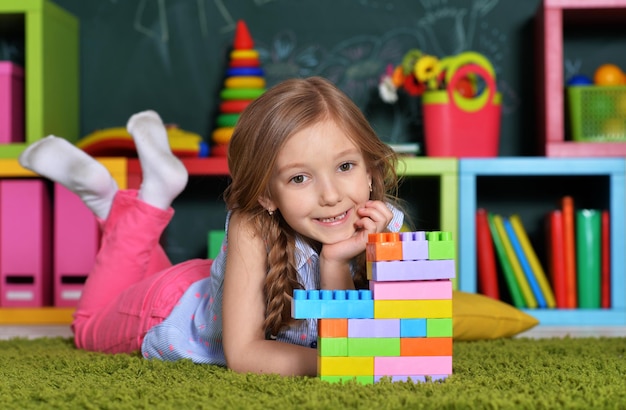 Entzückendes kleines Mädchen, das mit bunten Plastikblöcken spielt