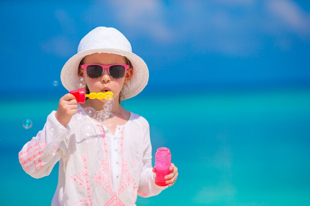 Entzückendes kleines Mädchen, das Seifenblasen während der Sommerferien macht