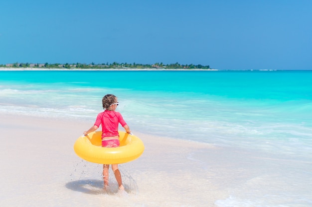 Entzückendes kleines Mädchen, das Spaß auf dem Strand hat