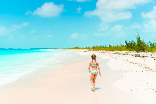 Entzückendes kleines Mädchen haben Spaß am tropischen Strand während des Urlaubs