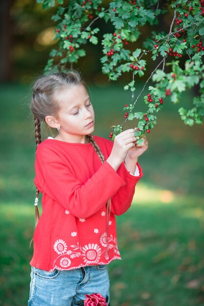 Entzückendes kleines Mädchen in blühendem Apfelbaumgarten am Frühlingstag