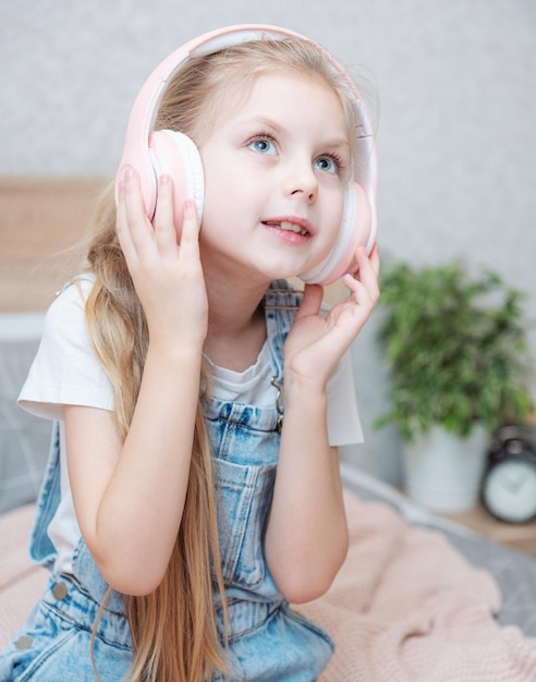 Entzückendes kleines Mädchen in den Kopfhörern genießt mit einer Musik