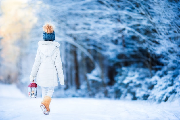 Entzückendes kleines Mädchen mit Taschenlampe im Winter auf Weihnachten draußen