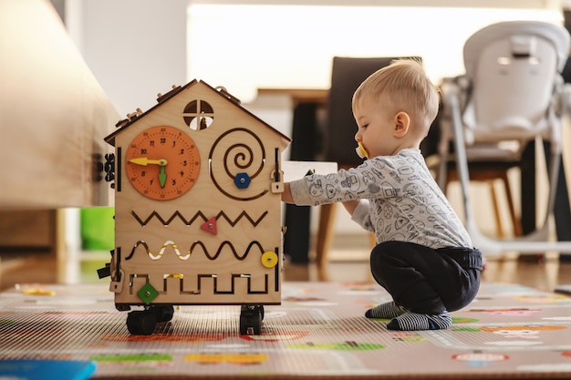 Entzückendes Kleinkind, das interaktive Spiele für eine gute Entwicklung zu Hause spielt.