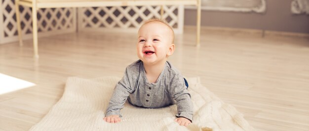 Entzückendes lachendes Baby im sonnigen Schlafzimmer