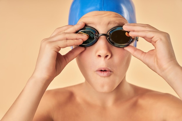 Entzückendes männliches Kind, das eine Schwimmbrille aufsetzt