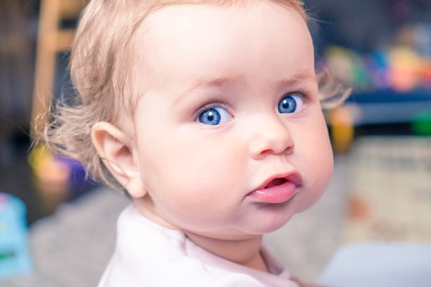 Entzückendes Säuglingsbabyporträt Kleines Mädchen mit blauen Augen, die zur Kamera schauen