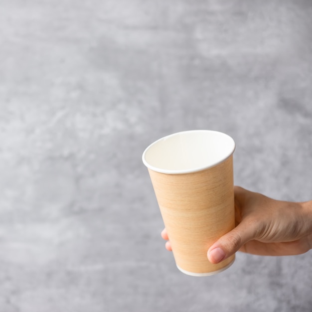 Envasado de alimentos ecológico o taza de café para llevar. Mano que sostiene el recipiente natural para llevar. desperdicio cero, contaminación, día de la tierra, plástico libre, concepto del día mundial del medio ambiente