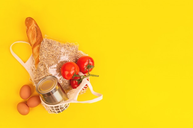 Envasado de alimentos sobre fondo amarillo. Entrega de alimentos en cuarentena a domicilio. Flatlay banner con copyspace.