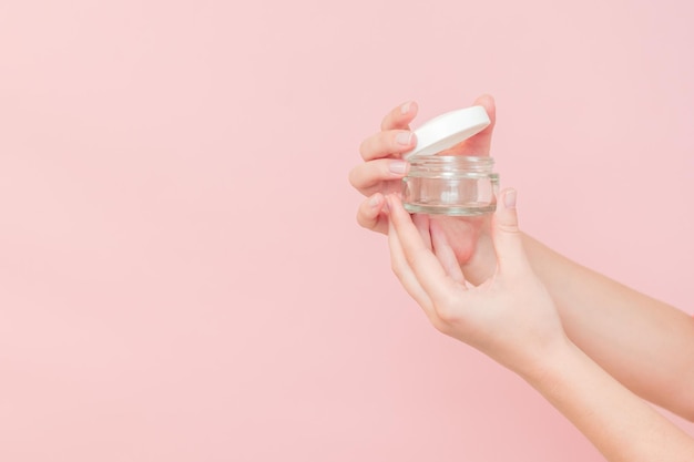 Foto envase de productos cosméticos de vidrio transparente para crema facial o cutánea en la mano envase para productos cosmético de belleza en un recipiente de maquillaje de lujo