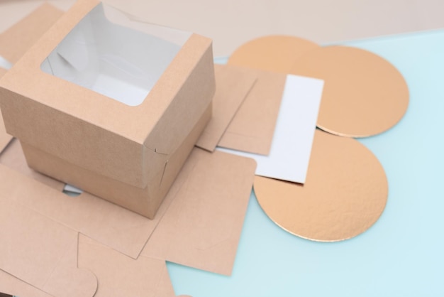 Foto envases desechables de cartón biodegradable con ventana para entrega de comida para llevar de cerca con enfoque selectivo caja artesanal para entrega de postres caseros