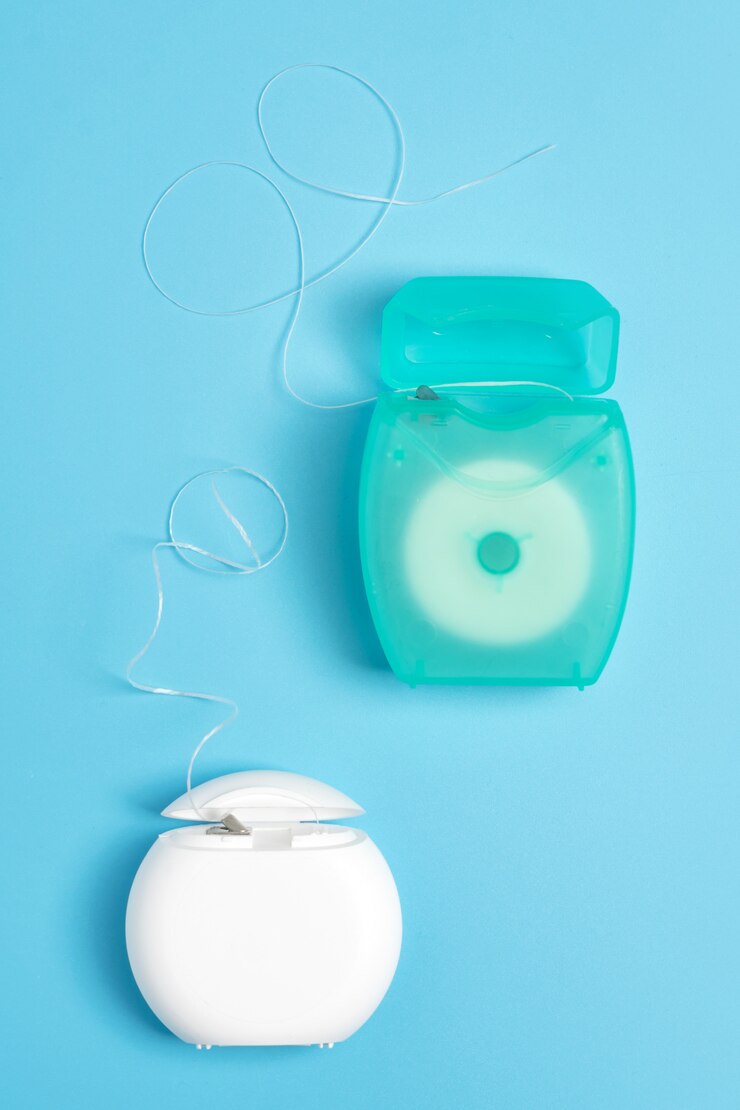 Foto envases de hilo dental sobre fondo azul. higiene oral diaria, cuidado de los dientes y salud. productos de limpieza para su boca, copie el espacio. concepto de cuidado dental