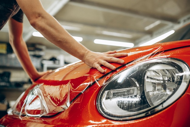 Envelopamento de carro com papel alumínio no serviço de carro