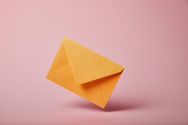 Envelope amarelo e colorido em fundo rosa com espaço de cópia