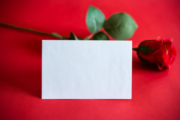 Envelope branco sobre fundo vermelho, para escrever uma carta de amor no Dia dos Namorados para o seu parceiro, ou para conquistar, e com uma rosa, símbolo de carinho. conceito de amor
