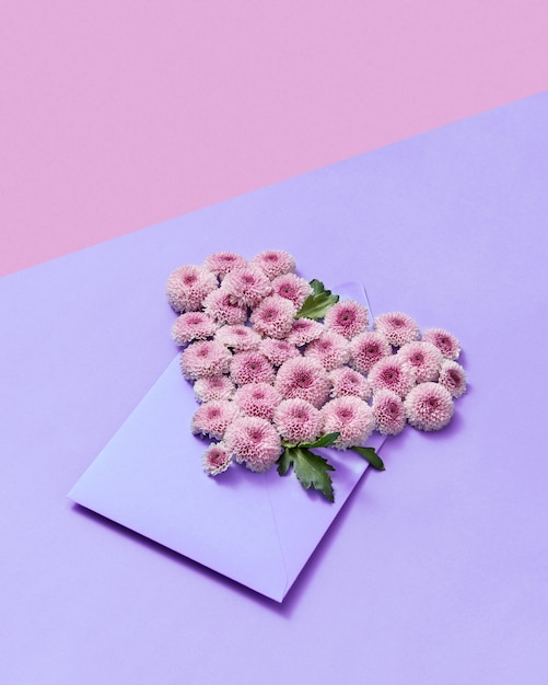 Envelope de artesanato com coração de flores de crisântemo resistente em um fundo pastel duotônico, copie o espaço. cartão de felicitações.