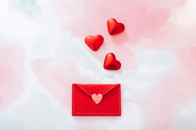Foto envelope de feltro com corações vermelhos para o dia dos namorados na vista superior de fundo colorido