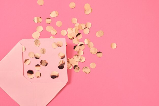 Envelope de papel timbrado de confete dourado em fundo rosa conceito de parabéns dia dos namorados cartão postal dia das mães presente de 8 de março