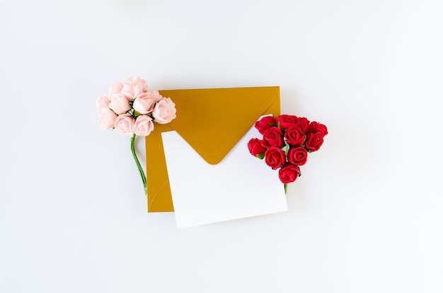 Envelope dourado com cartão e rosas no fundo branco