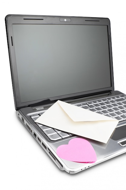 Foto envelope para cartas no laptop e a forma do coração. conceito em uma parede branca.