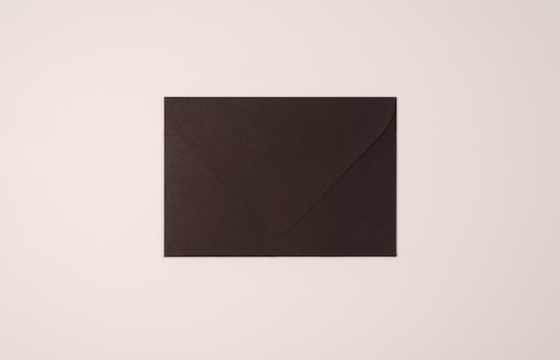 Envelope preto fechado sobre fundo claro de cor leitosa