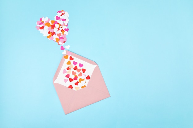 Foto envelope rosa com confetes em forma de coração