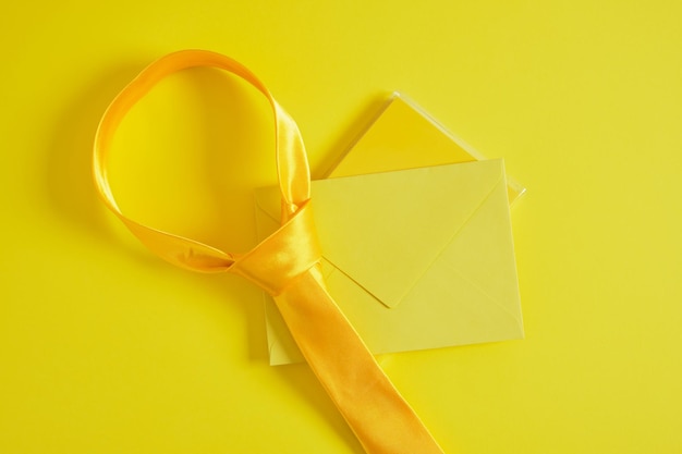 Envelope simulado de gravata amarela em fundo amarelo