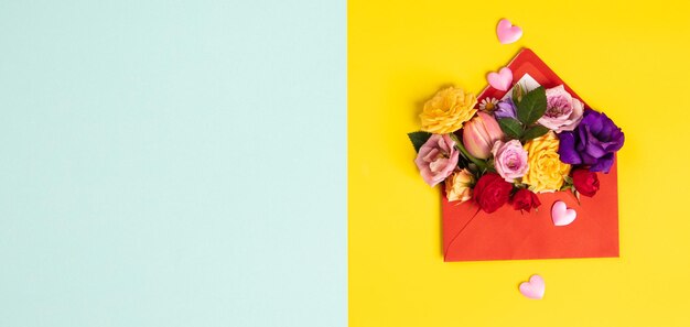 Envelope vermelho aberto com arranjos de flores em fundo amarelo