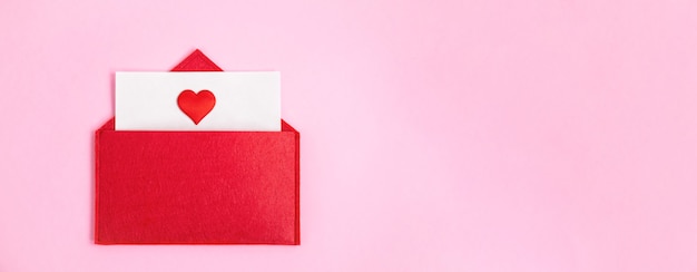 Envelope vermelho banner aberto com uma folha de papel com um coração em um fundo rosa