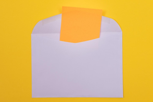 Envelope violeta com folha de papel laranja em branco dentro