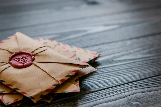 Envelopes antigos vintage retrô com um carimbo de cera na velha mesa de madeira marrom escura