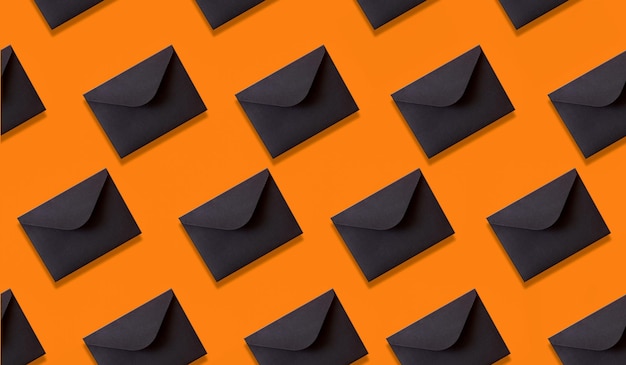 envelopes pretos sem costura padrão em fundo laranja.