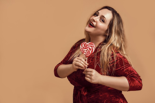 Enviándote mi amor mujer feliz de talla grande en vestido de terciopelo con forma de corazón rojo