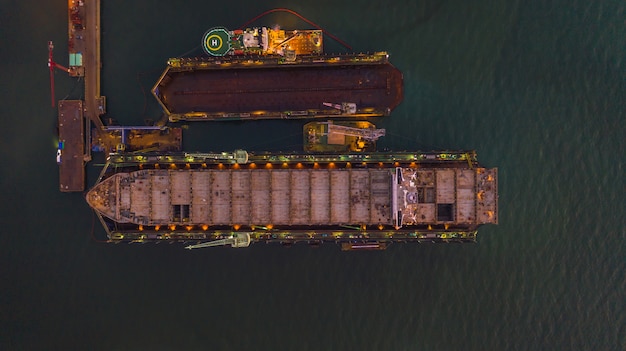 Foto envíe en vista aérea del astillero, envíe en un muelle seco flotante en reparación mediante arenado y pinte en el astillero.