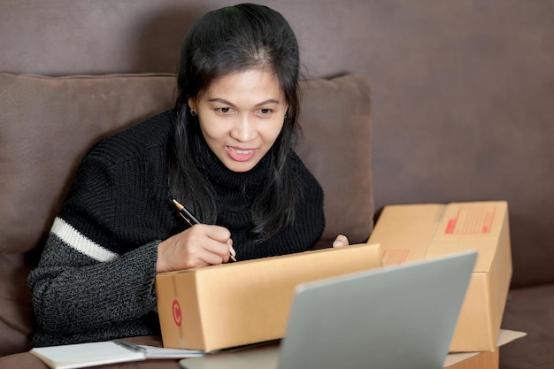 Envío en línea mujer asiática puesta en marcha propietario de una pequeña empresa La lista de verificación acepta el pedido en línea